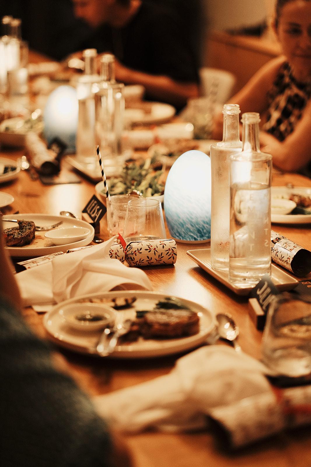 A long dinner table set for the group, candles and flowers down its length