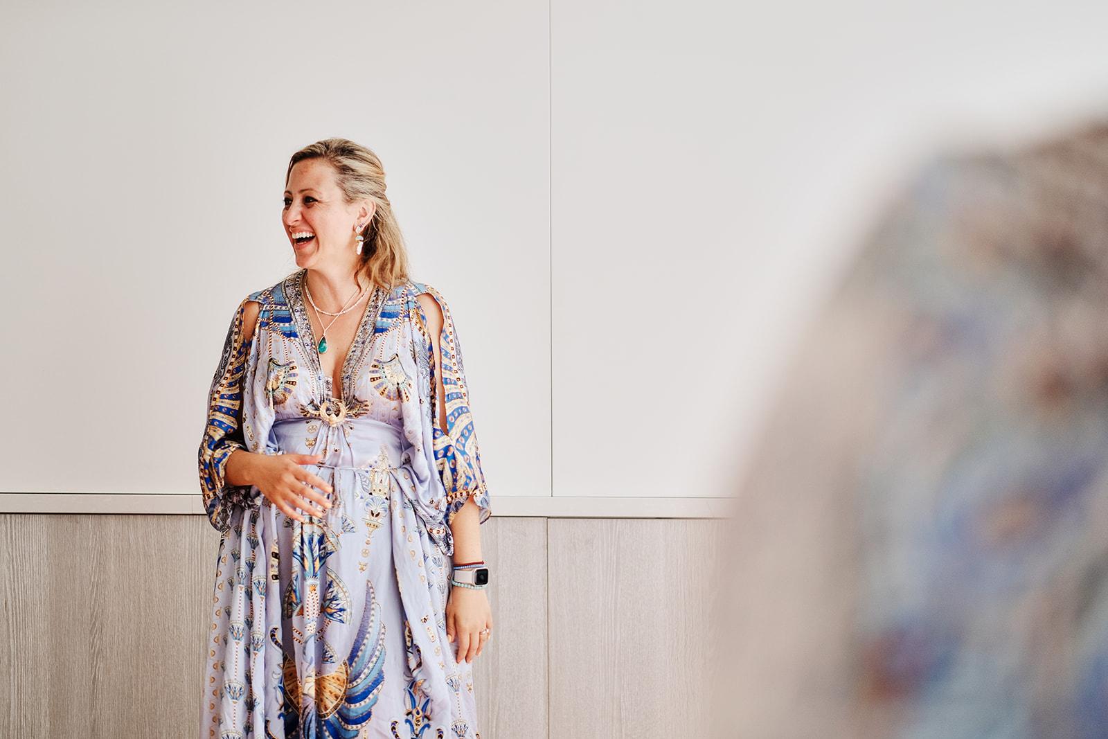 A woman laughing mid-conversation indoors