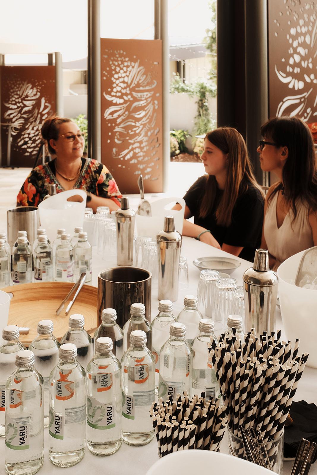 Bottles, mixers and paper straws set out at the mocktail bar