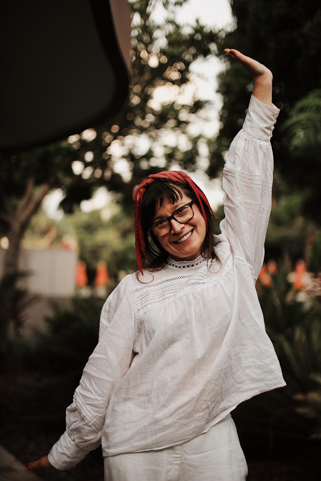 Portrait of a woman from the retreat mid-twirl, arm raised