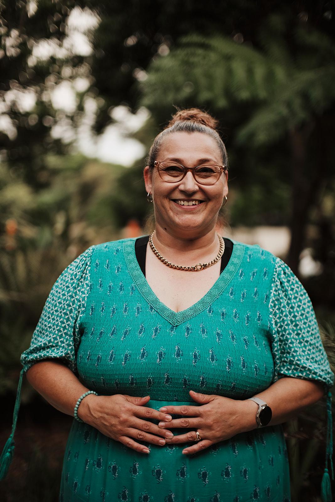 Portrait of a woman from the retreat smiling, hand resting on her stomach