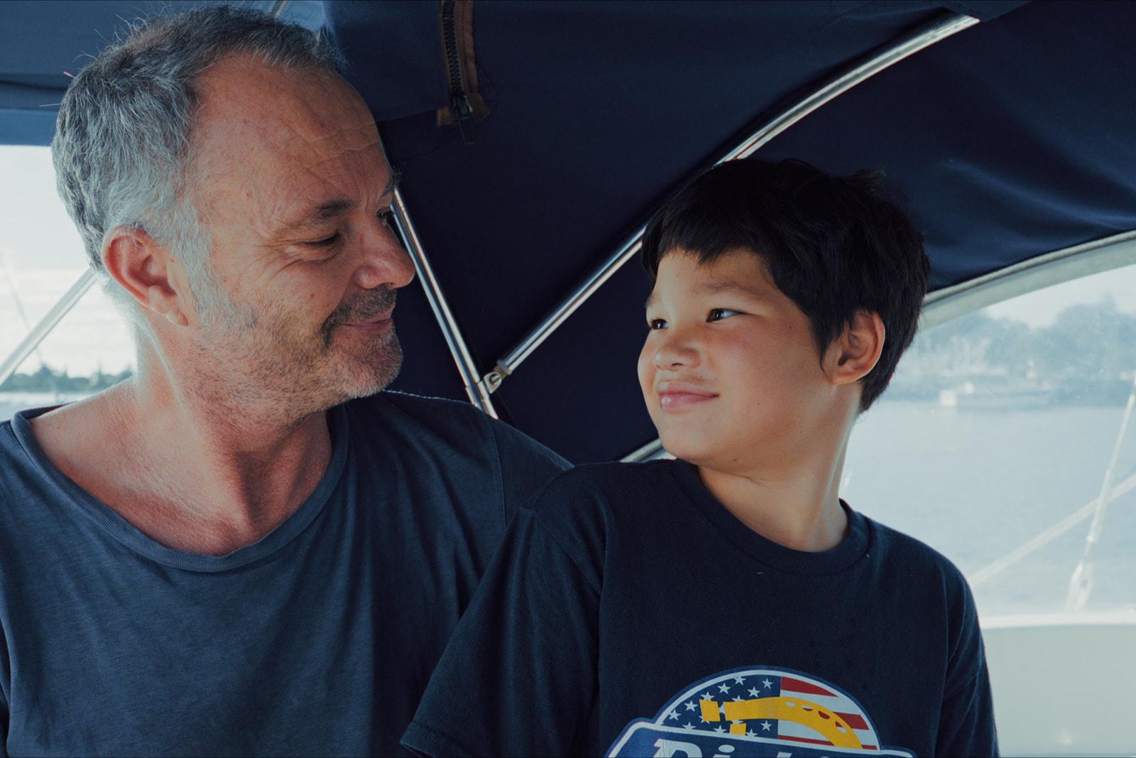 Nharyan and Koa smiling at each other under the boat's boom tent