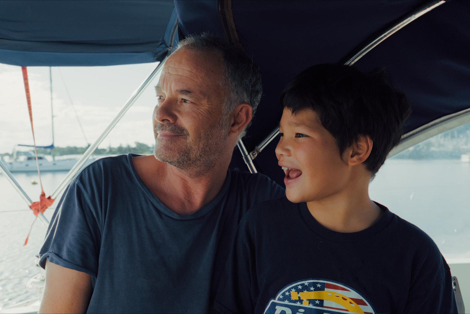 Nharyan and Koa laughing together under the boat's canopy