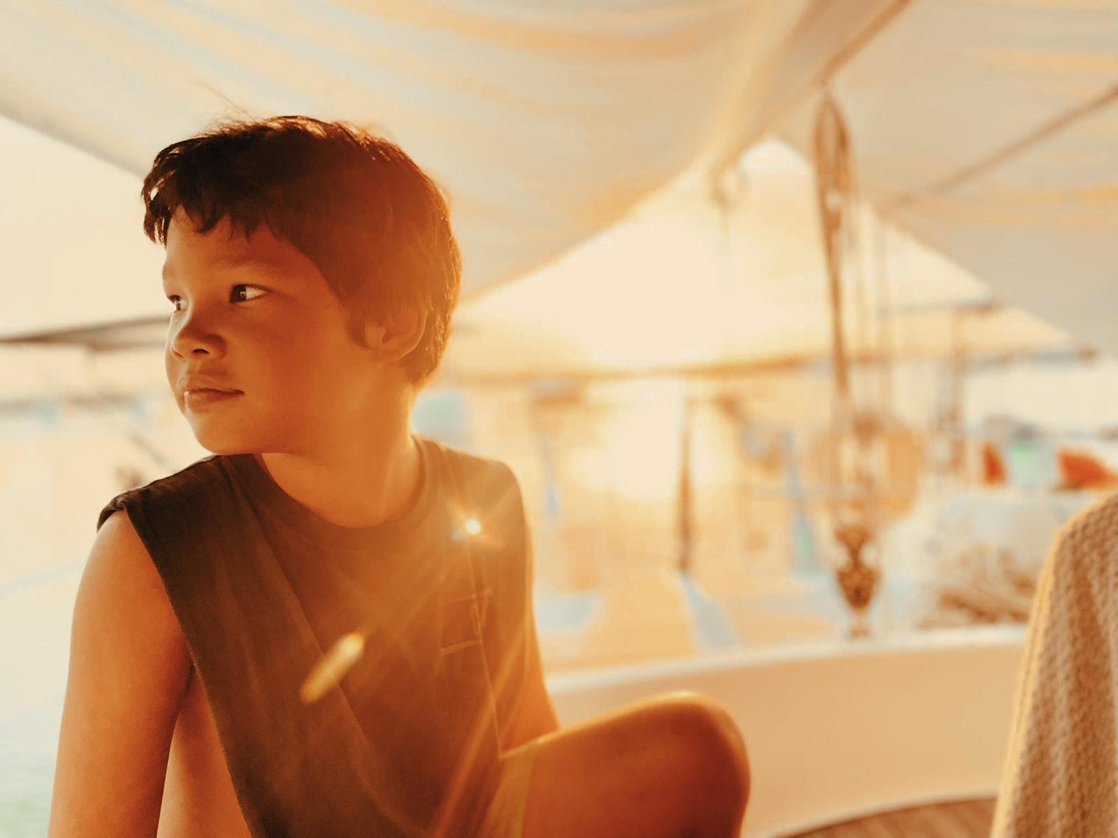 Koa lit by golden-hour light under the boat's awning