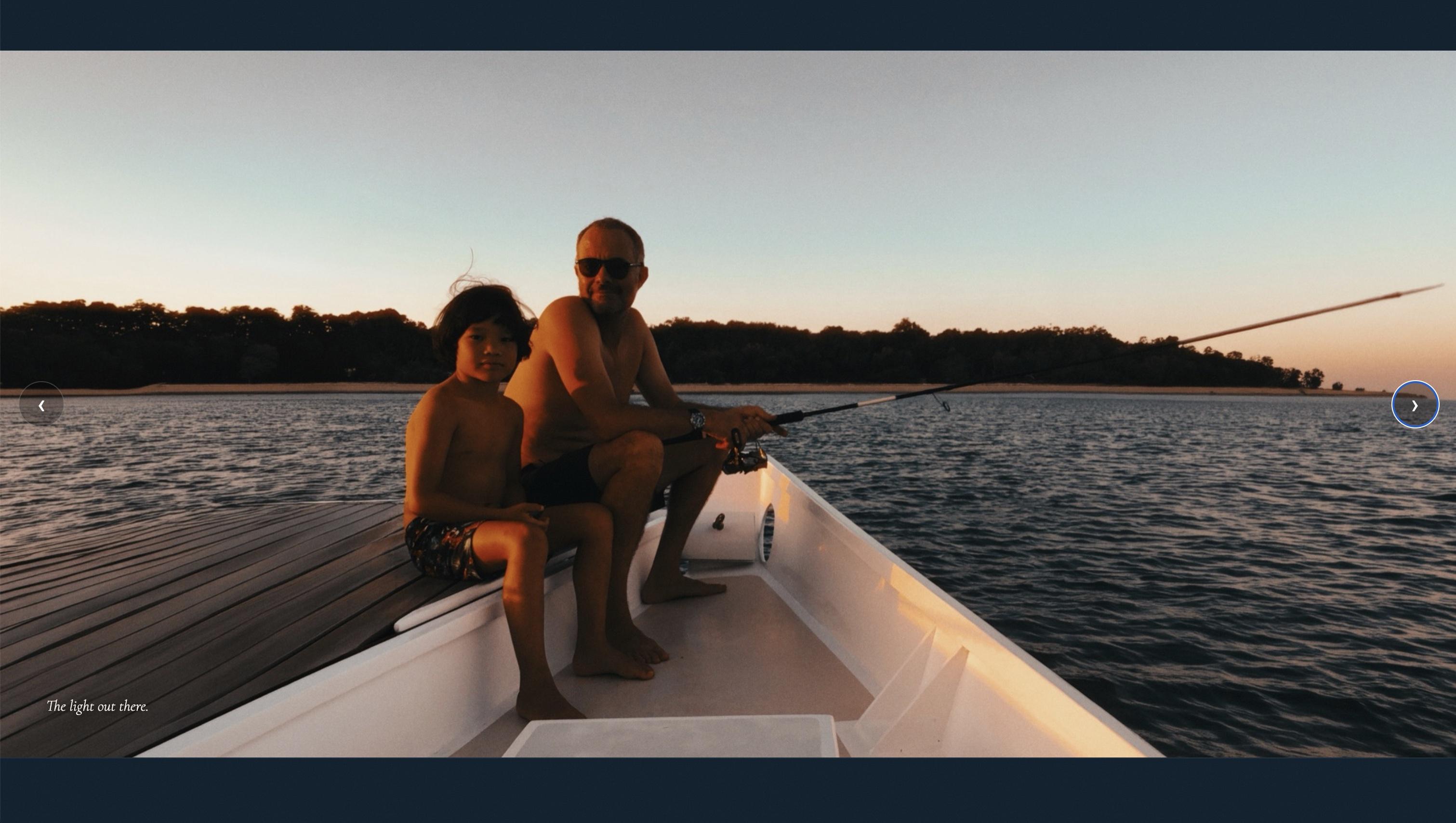 Full-bleed photo of father and son fishing off the bow at dusk, captioned 'The light out there.'