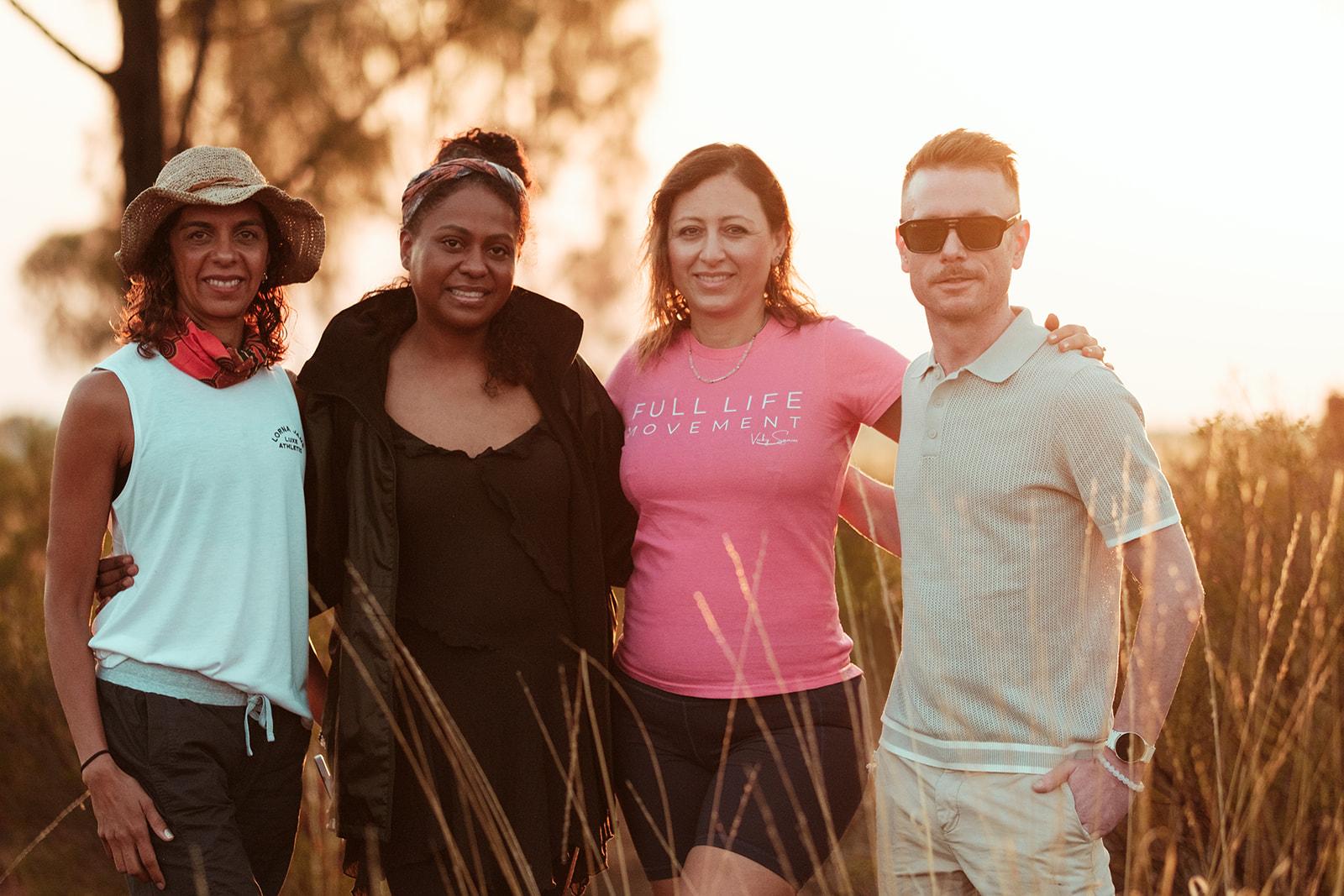 The group walking together arm in arm through the bush