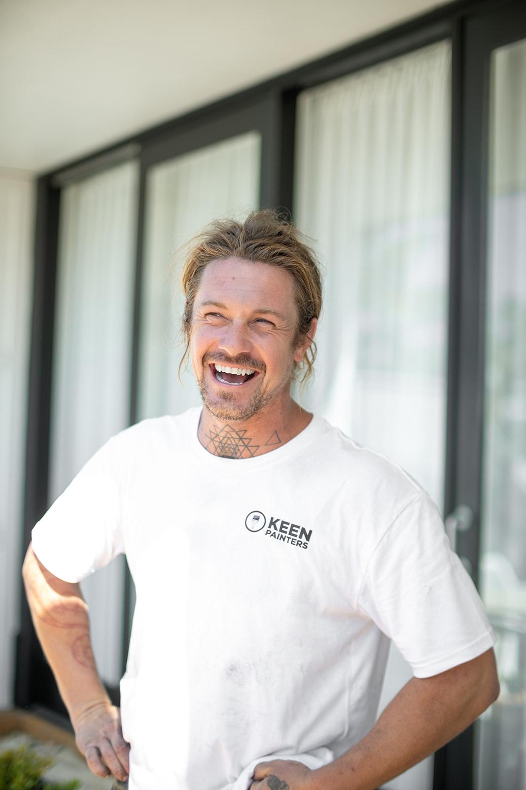 A Keen Painters crew member laughing on site, hands on hips