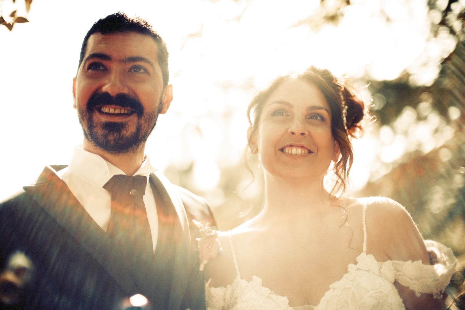 A couple backlit by golden-hour sun under trees at an Italian wedding