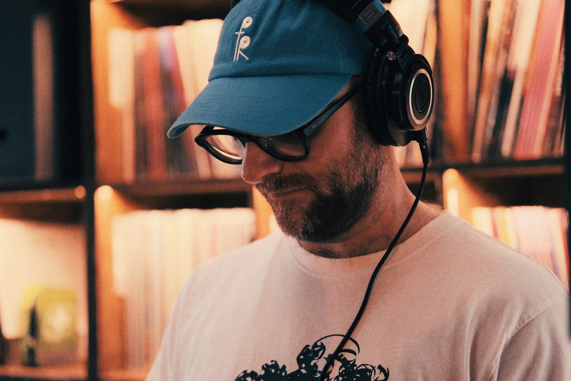 A close-up of the DJ in his blue cap and headphones, looking down