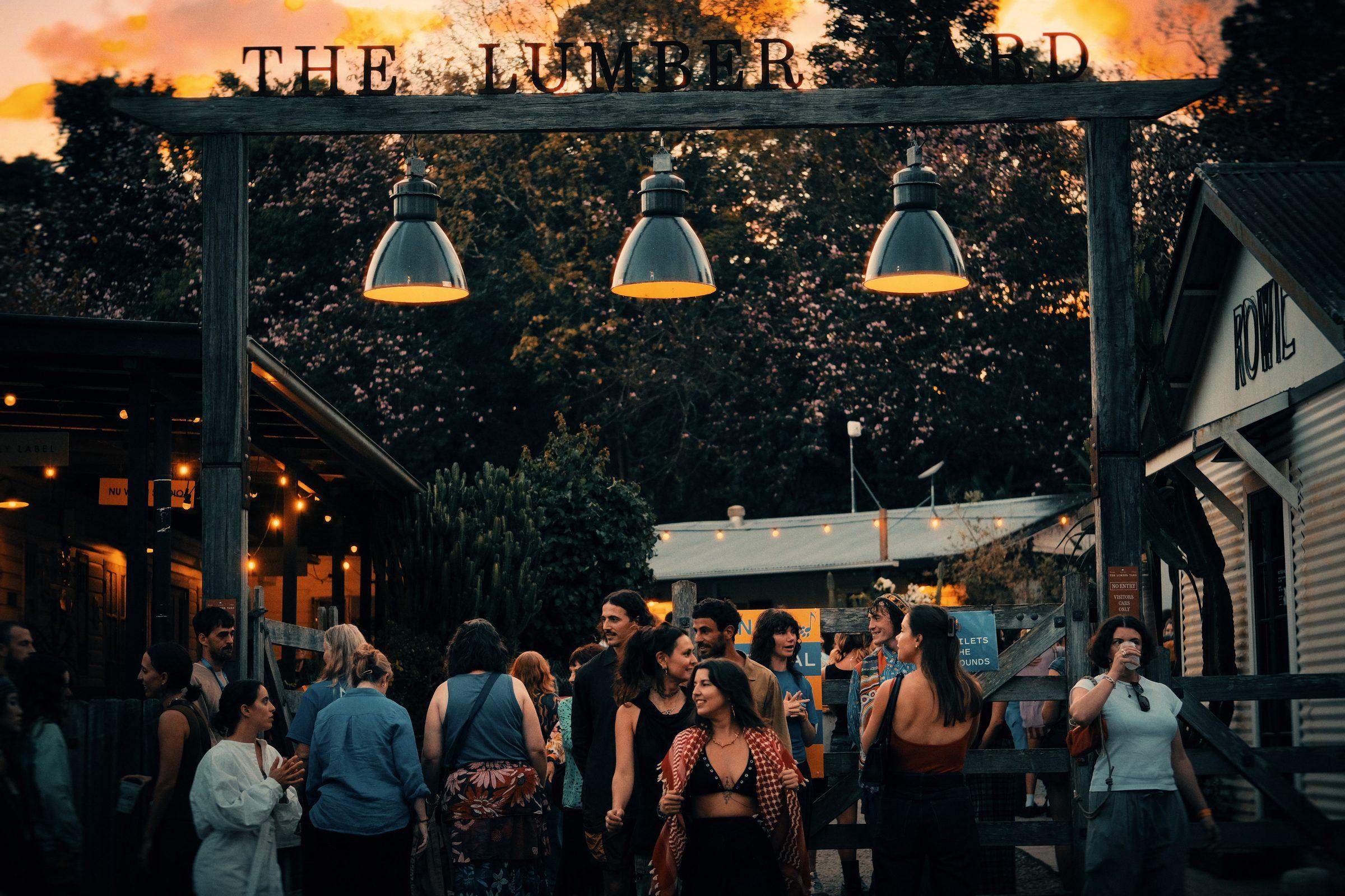 The Lumber Yard at dusk, a crowd under string lights beneath its sign